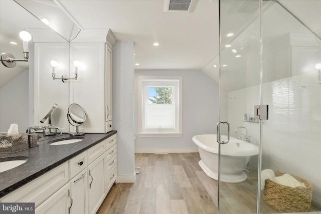 1071 Highland Rd, Newtown, PA 18940 - full bath with double vanity, wood finished floors, a freestanding tub, vaulted ceiling, and a shower stall