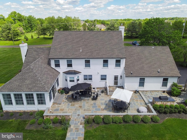 1071 Highland Rd, Newtown, PA 18940 - back of property with a chimney, roof with shingles, a patio, and outdoor dining space