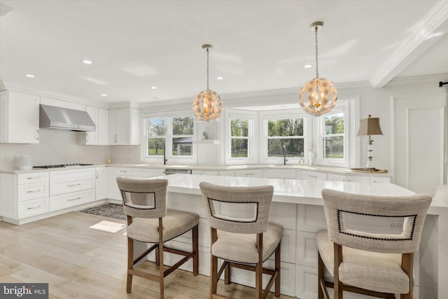1071 Highland Rd, Newtown, PA 18940 - kitchen with wall chimney range hood, a chandelier, light countertops, crown molding, and stovetop
