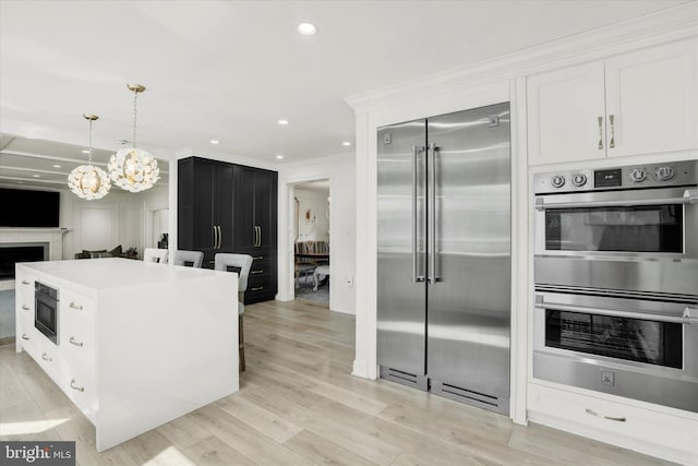 1071 Highland Rd, Newtown, PA 18940 - kitchen with appliances with stainless steel finishes, ornamental molding, white cabinetry, a chandelier, and hanging light fixtures