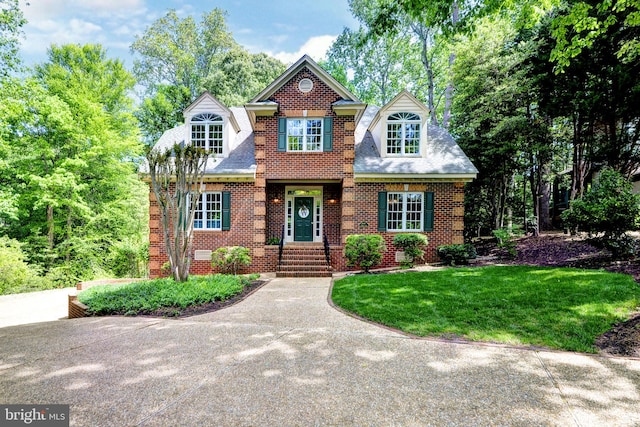 traditional-style house featuring brick siding and a front yard