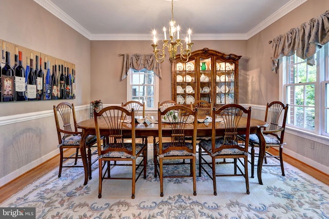 dining room with baseboards, crown molding, wood finished floors, and a notable chandelier