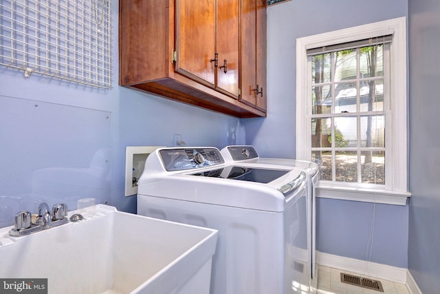 laundry area with visible vents, baseboards, a sink, cabinet space, and independent washer and dryer