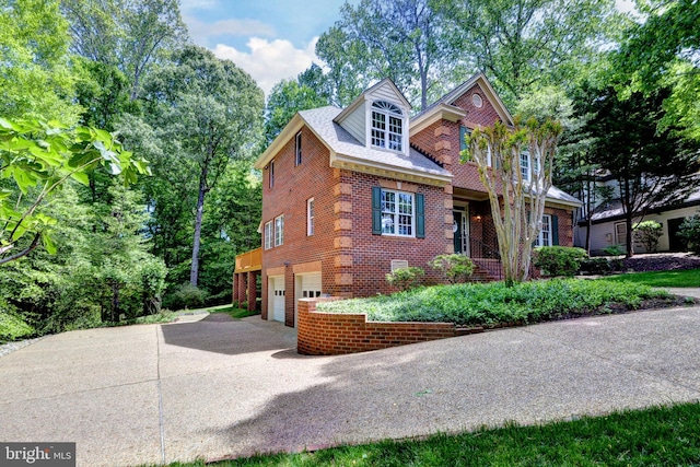 view of front of house with brick siding, driveway, and a garage