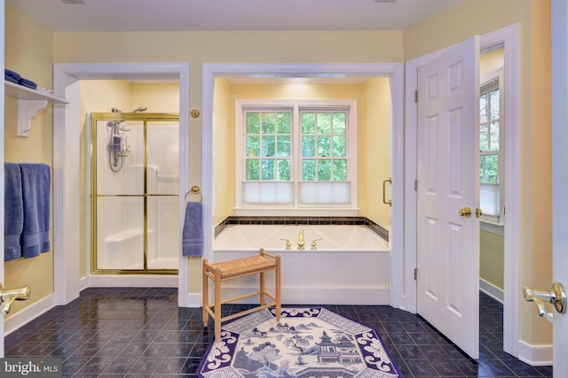 bathroom with baseboards, a shower stall, tile patterned floors, and a garden tub