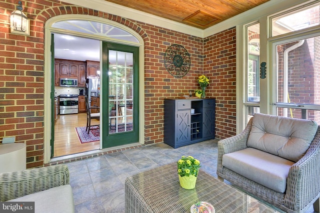 interior space featuring ornamental molding, wood ceiling, stone finish flooring, and brick wall