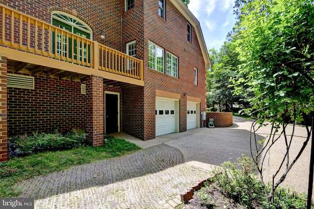 exterior space with a garage, driveway, and brick siding