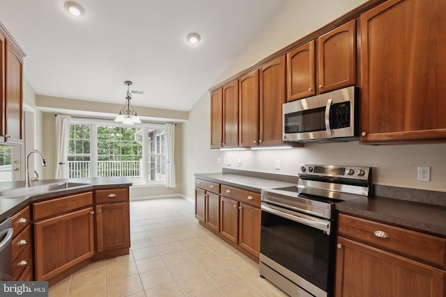 kitchen featuring dark countertops, light tile patterned floors, a sink, lofted ceiling, and stainless steel appliances