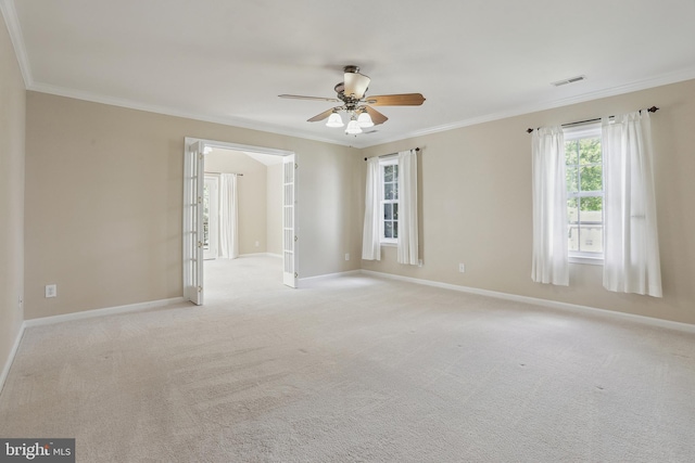 unfurnished room featuring crown molding, a ceiling fan, baseboards, and visible vents