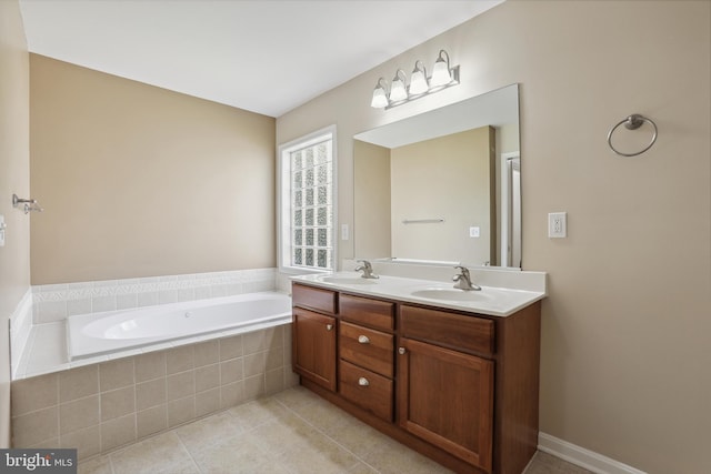 bathroom with a sink, tile patterned floors, a bath, and double vanity