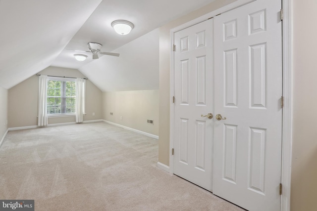 bonus room with baseboards, a ceiling fan, lofted ceiling, and light colored carpet