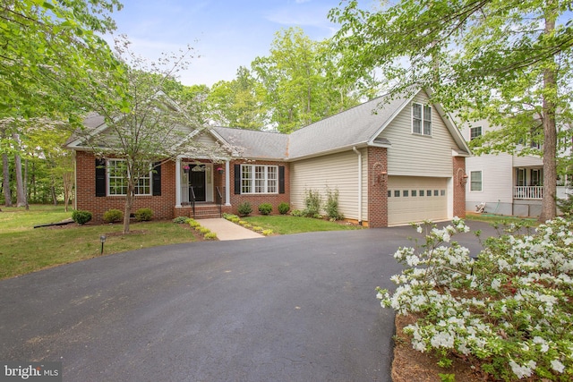 view of front facade featuring brick siding, an attached garage, a front yard, and aphalt driveway