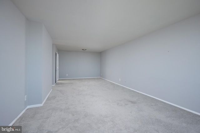 carpeted spare room with baseboards