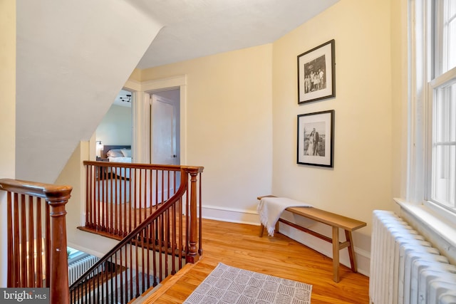 staircase with radiator, baseboards, and wood finished floors