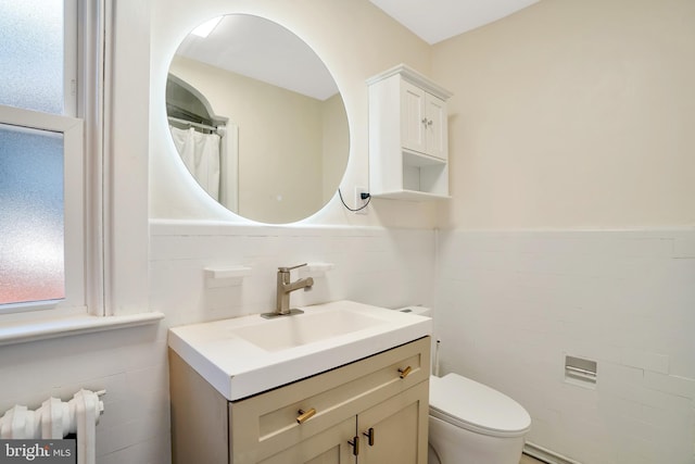 full bathroom with tile walls, a wainscoted wall, vanity, and toilet