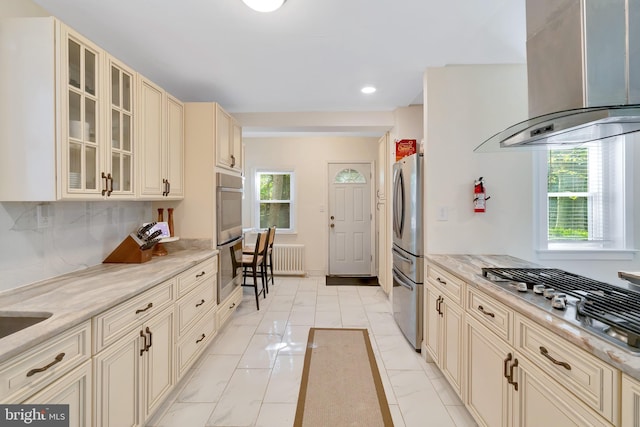 kitchen with marble finish floor, stainless steel appliances, recessed lighting, wall chimney exhaust hood, and cream cabinetry