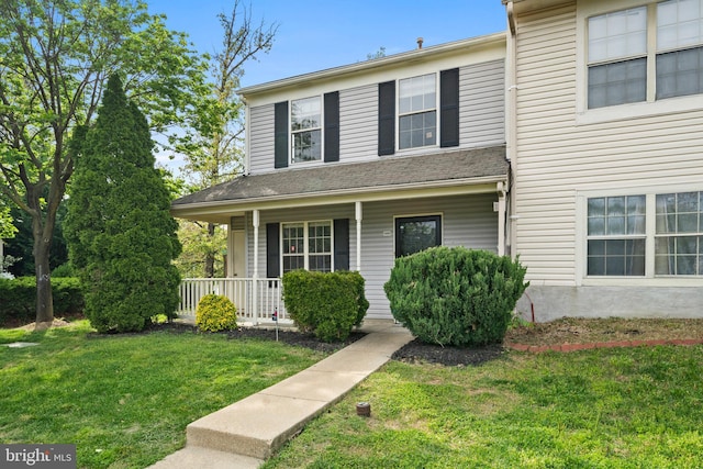 view of front of home with a porch and a front yard
