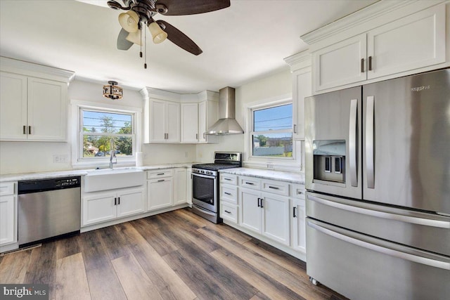 9 Biscayne Blvd, West Deptford, NJ 08096 - kitchen featuring wall chimney range hood, a ceiling fan, appliances with stainless steel finishes, a sink, and white cabinetry