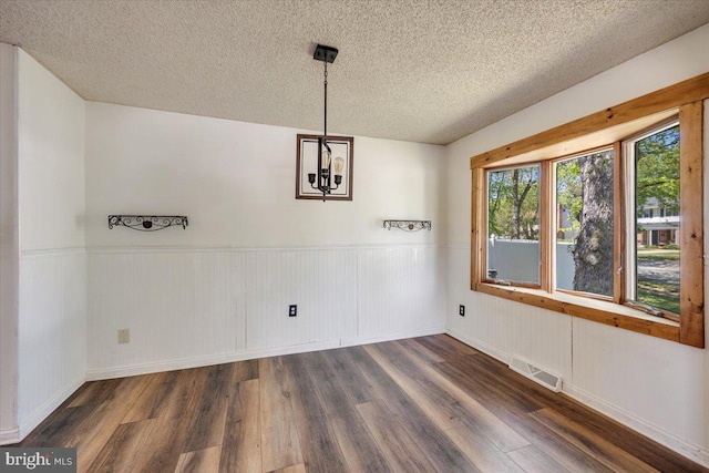 9 Biscayne Blvd, West Deptford, NJ 08096 - unfurnished dining area with visible vents, a textured ceiling, wood finished floors, and wainscoting