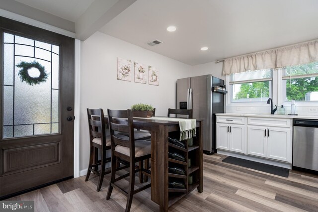 dining area with recessed lighting, visible vents, and wood finished floors