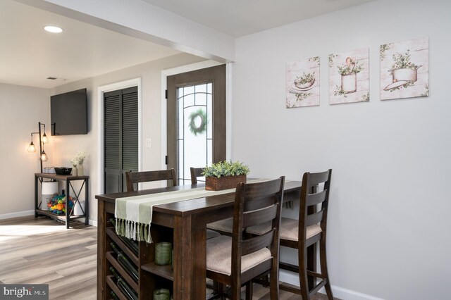dining room featuring light wood-style floors, baseboards, and recessed lighting