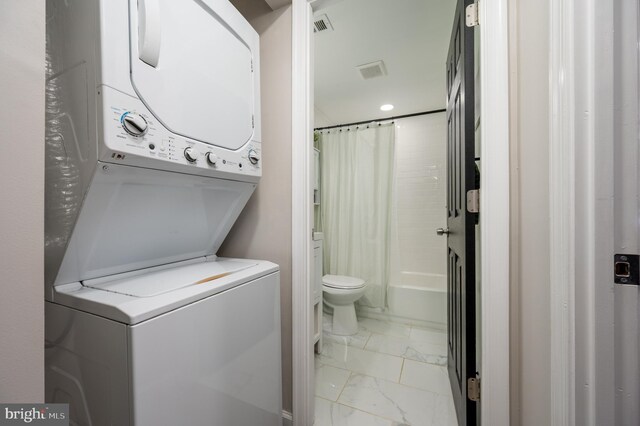 full bathroom with stacked washer / drying machine, shower / bath combo, toilet, marble finish floor, and recessed lighting