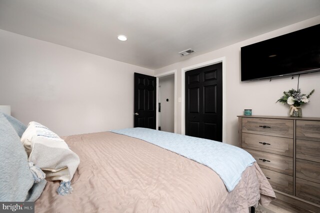 bedroom with recessed lighting, visible vents, and wood finished floors