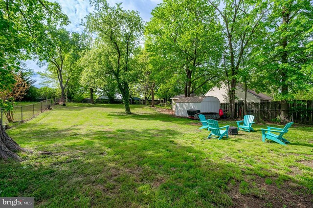 view of yard featuring a storage shed, an outdoor structure, and a fenced backyard