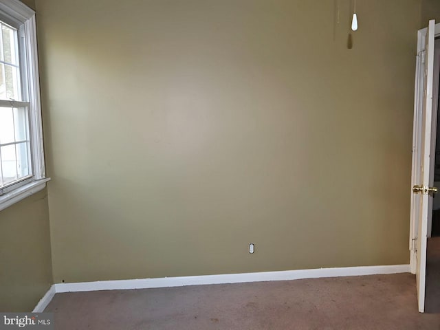 empty room featuring baseboards and carpet