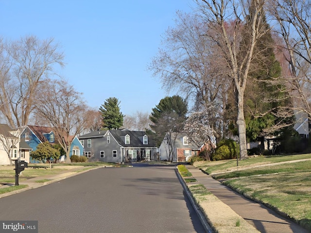 view of street with a residential view, sidewalks, and curbs