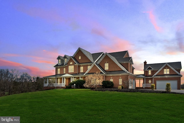 view of front of property with a porch, a front yard, concrete driveway, and brick siding