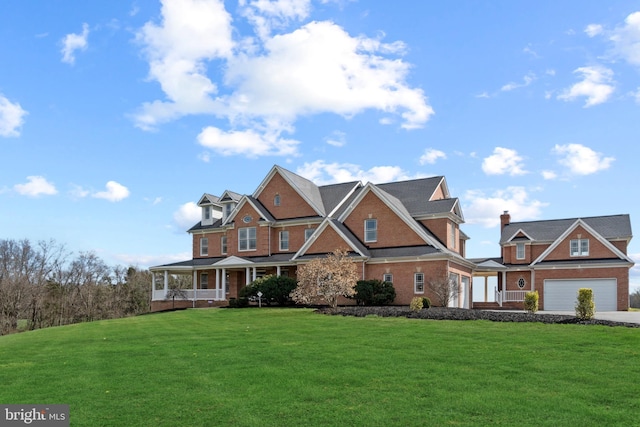 view of front of house with a porch, a front yard, an attached garage, and driveway