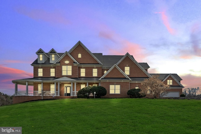 view of front of property featuring brick siding, a front yard, and covered porch