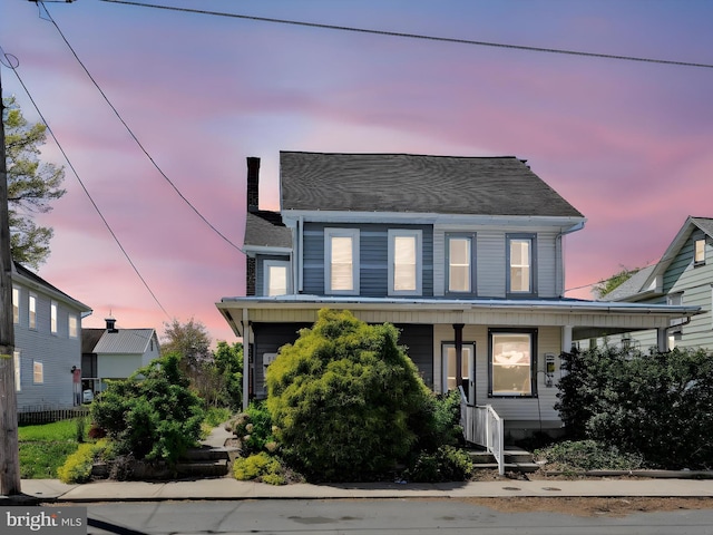 traditional-style home featuring fence, a shingled roof, and a porch