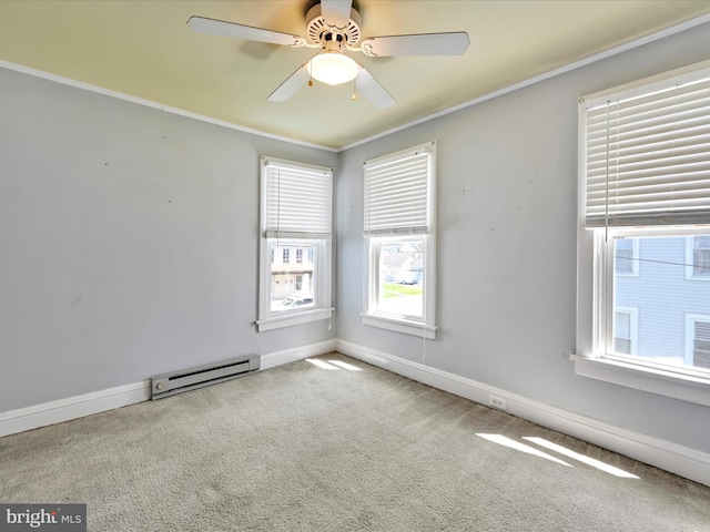 carpeted empty room with crown molding, baseboards, ceiling fan, and a baseboard heating unit