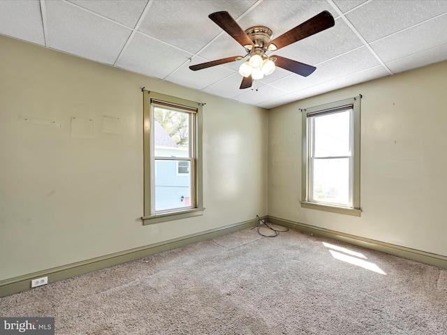 unfurnished room featuring baseboards, carpet flooring, and a drop ceiling