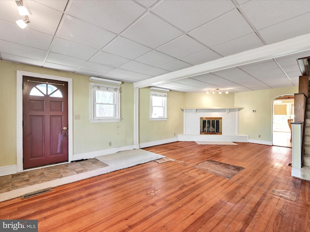 entrance foyer featuring visible vents, arched walkways, baseboards, and hardwood / wood-style flooring