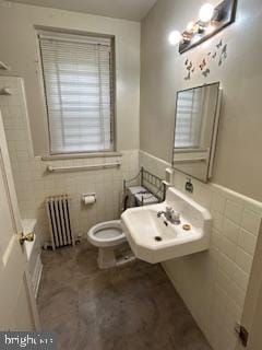 2702 30th St SE Unit A250, Washington, DC 20020 - bathroom with toilet, tile walls, wainscoting, and radiator