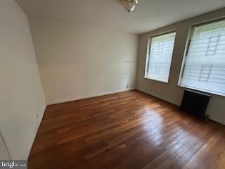 2702 30th St SE Unit A250, Washington, DC 20020 - empty room featuring radiator and wood finished floors