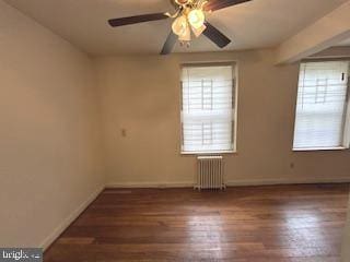 empty room featuring baseboards, radiator, ceiling fan, and wood finished floors