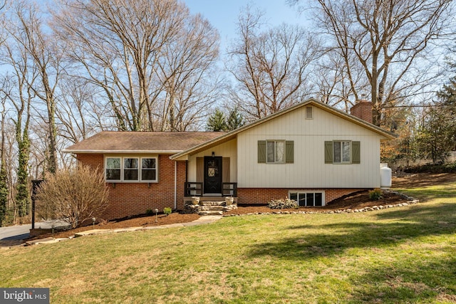 tri-level home featuring brick siding, a front lawn, and a chimney