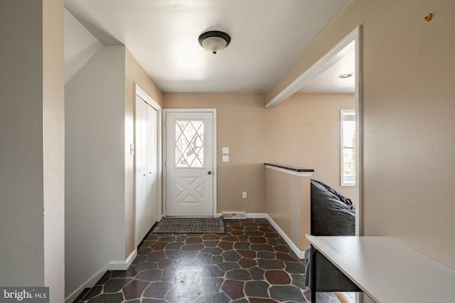 entrance foyer with baseboards, stone finish flooring, and visible vents