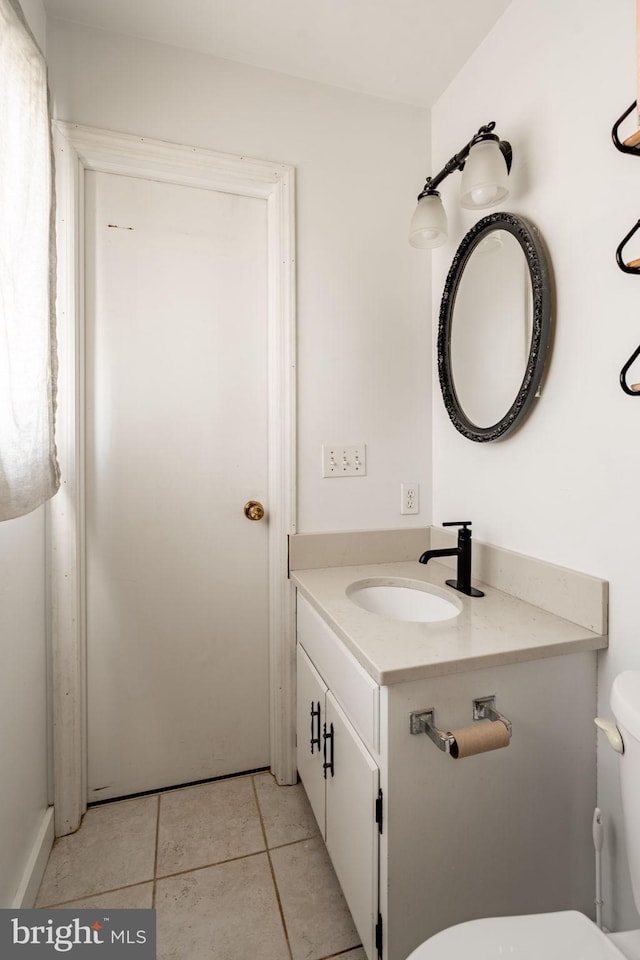 half bath featuring toilet, tile patterned flooring, and vanity