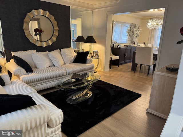 living area with crown molding, baseboards, wood finished floors, and a chandelier