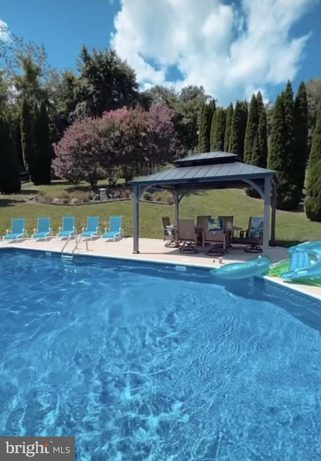 community pool with a gazebo and a yard