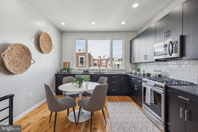 1211 Annin St, Philadelphia, PA 19147 - kitchen with dark countertops, light wood-style floors, appliances with stainless steel finishes, tasteful backsplash, and recessed lighting