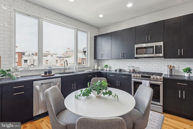 1211 Annin St, Philadelphia, PA 19147 - kitchen with dark cabinets, a sink, dark countertops, stainless steel appliances, and light wood-style floors
