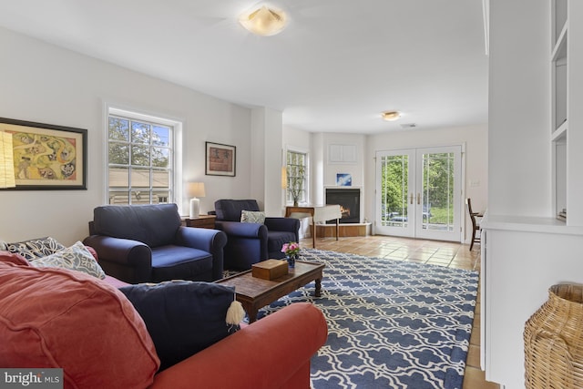tiled living room featuring visible vents, a healthy amount of sunlight, and french doors