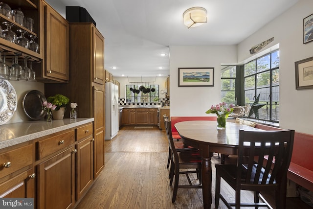 dining area with recessed lighting, a wealth of natural light, and wood finished floors