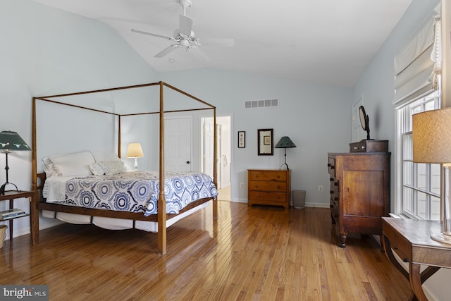bedroom with high vaulted ceiling, light wood-style flooring, and visible vents